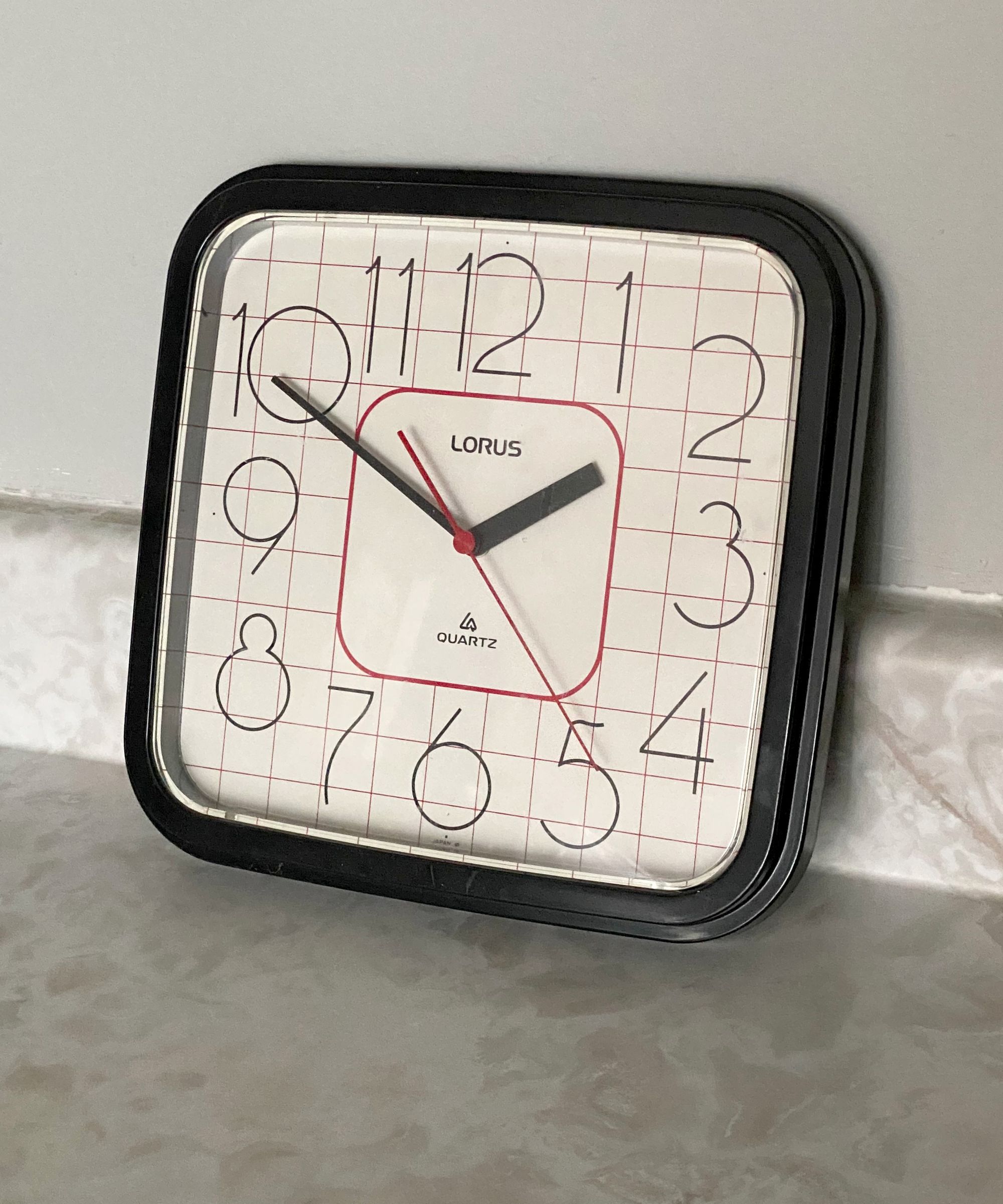 Lorus wall clock propped up on a kitchen counter.