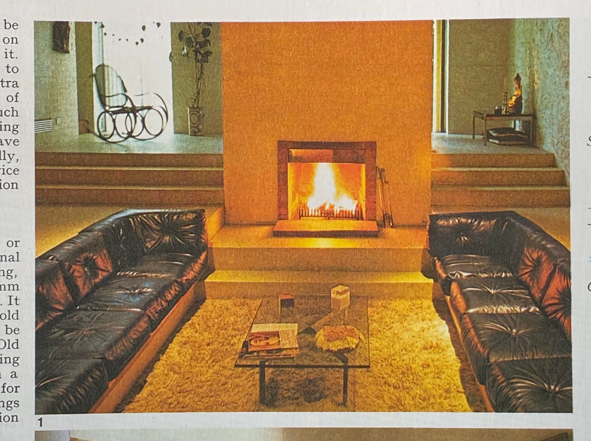 Sunken living room with shag carpet, leather sofas and a fireplace.