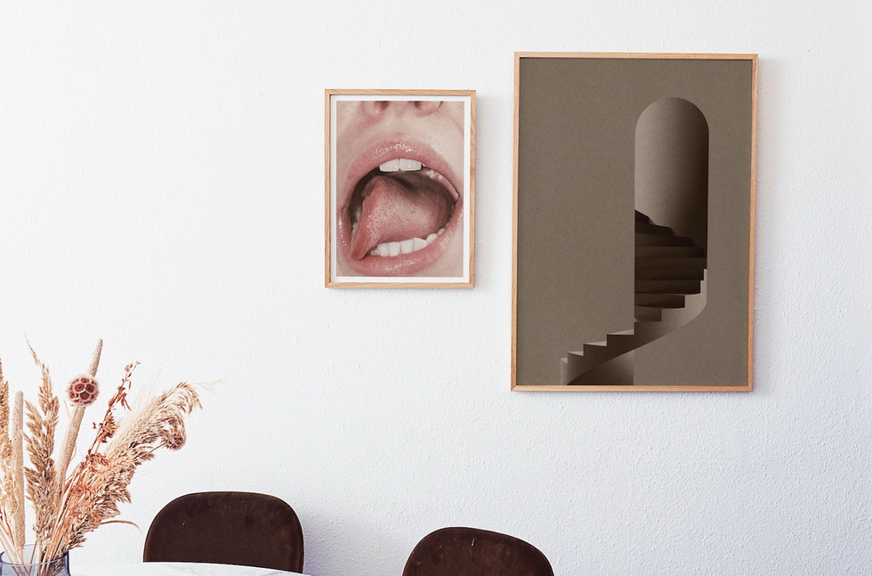 Dining room with two posters on the wall, one a photo of an open mouth with the tongue sticking out sideways and the other an illustration of a spiral staircase entering an arched doorway