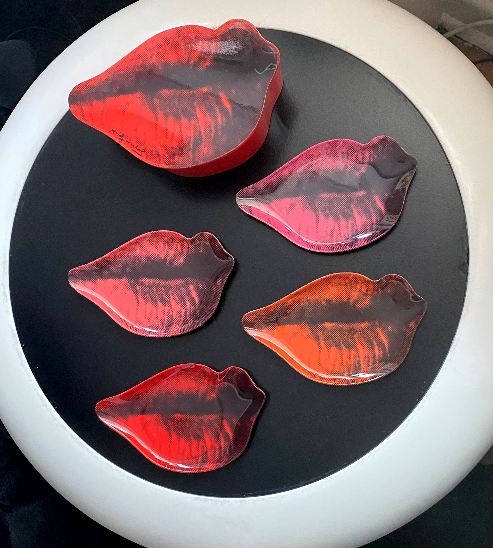 Table top with four Andy Warhol lips coasters and their box