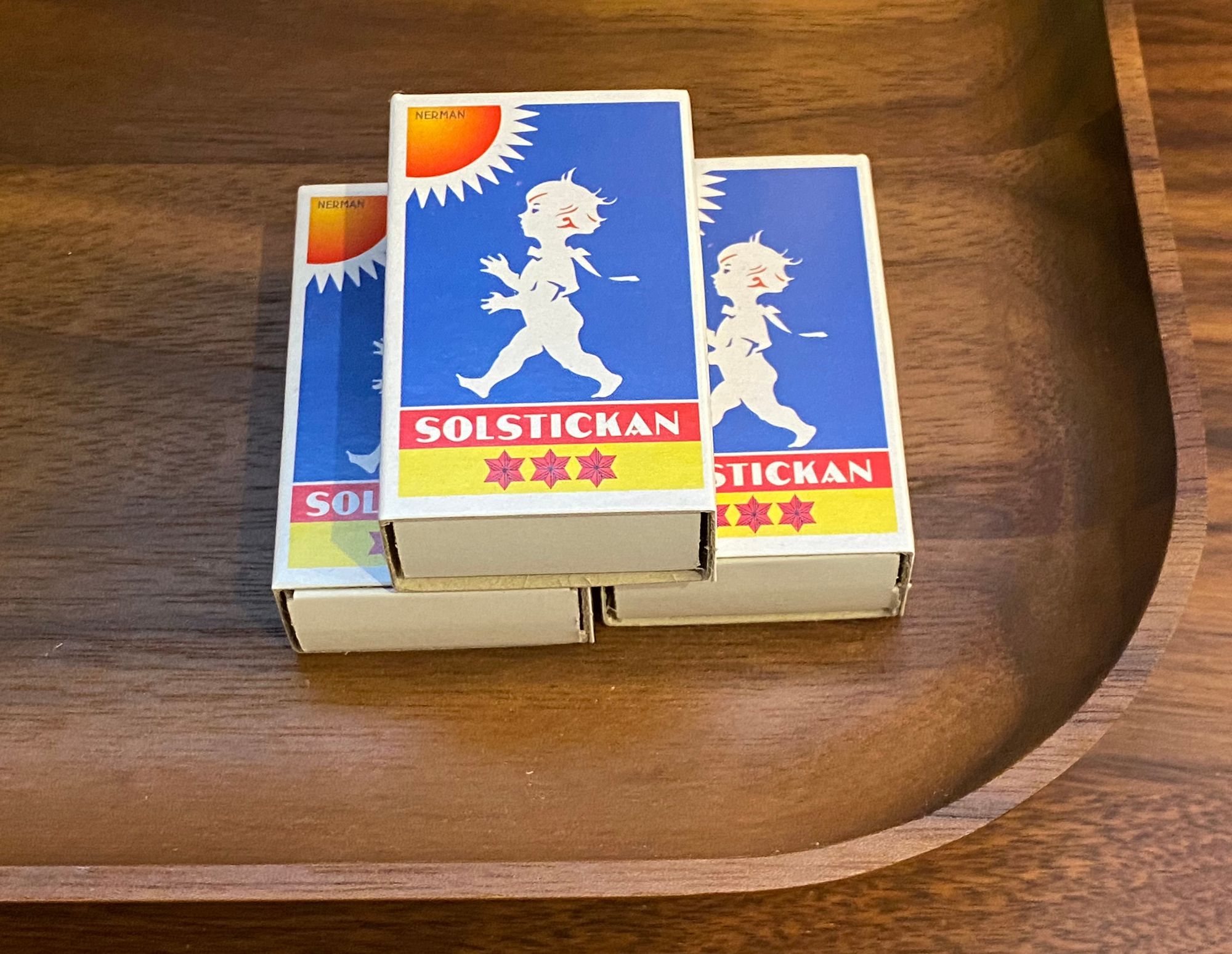 Three Solstickan matchboxes on a wooden tray