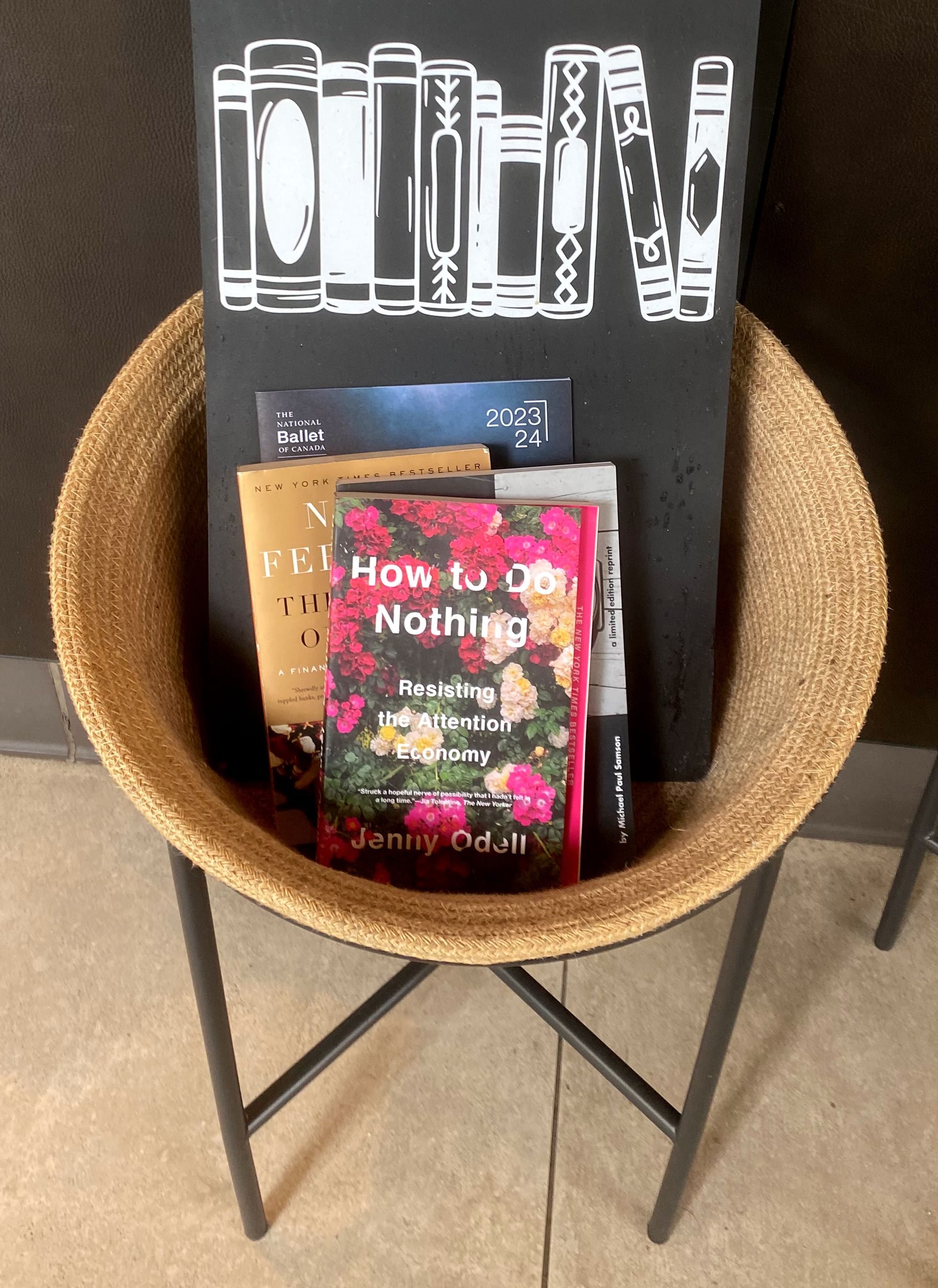 "How to Do Nothing" by Jenny Odell in a basket with other books.