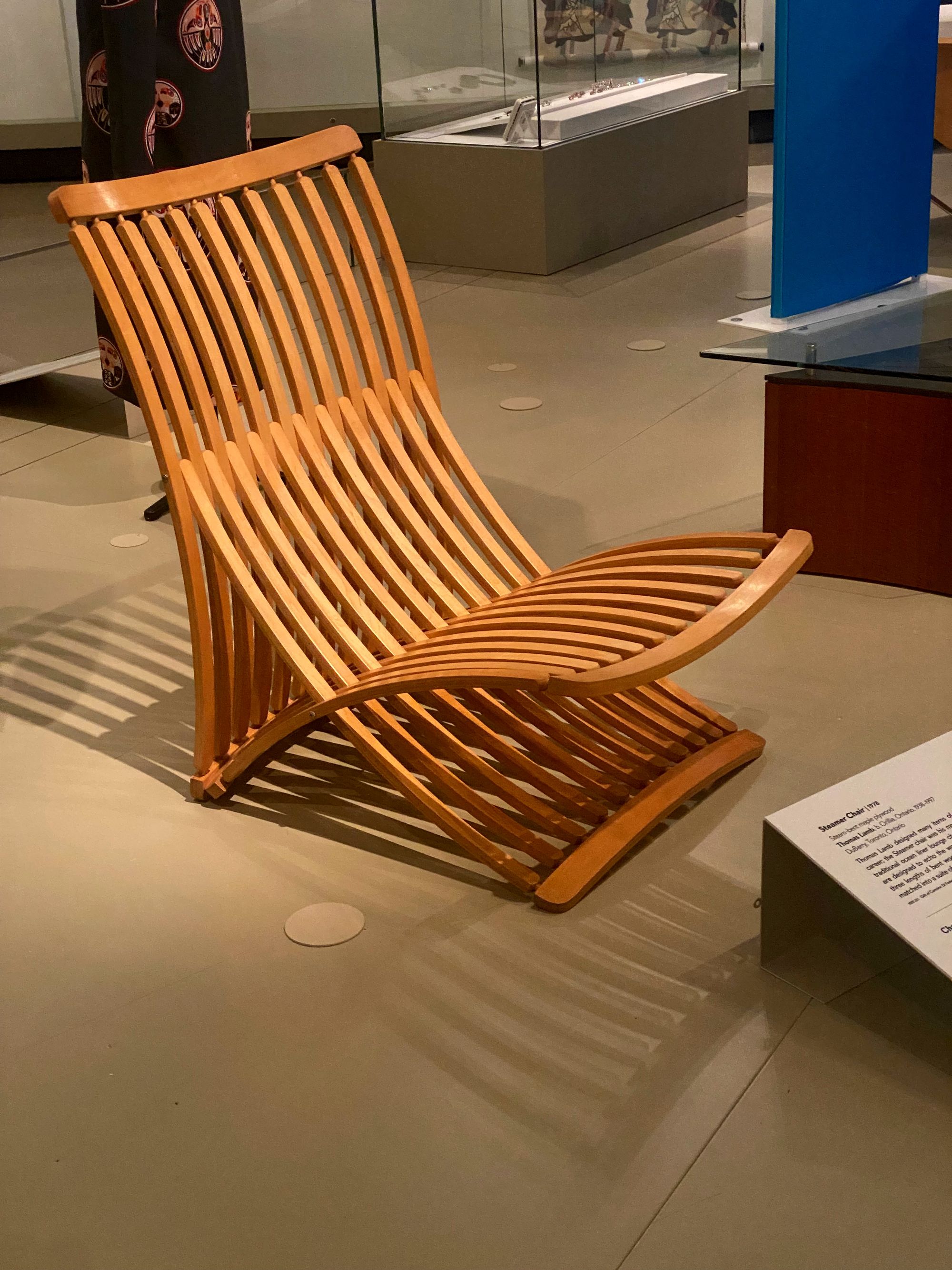 Lounge chair made of elegantly curved wooden slats.