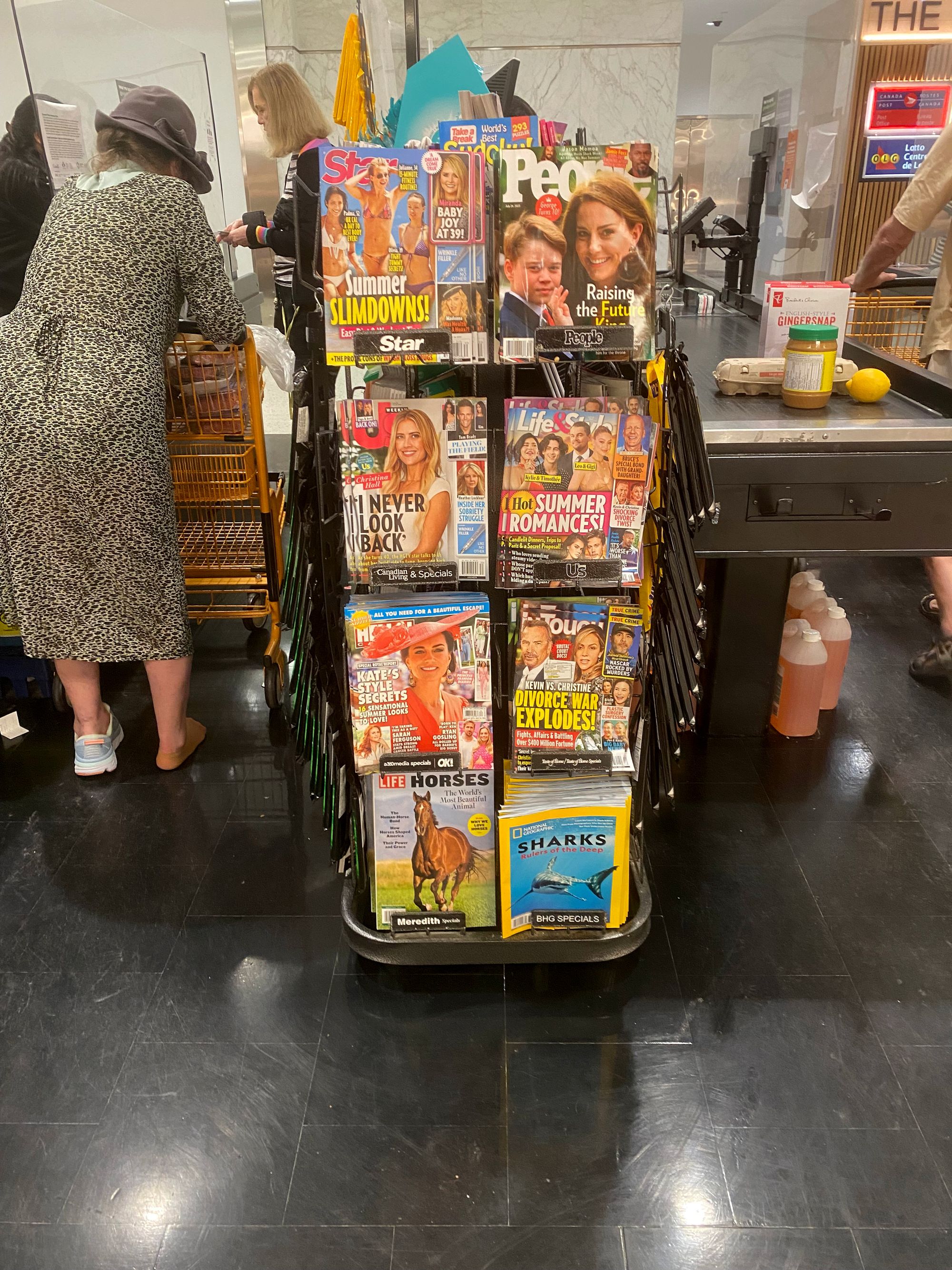 A vertical rack with eight sheaves of magazines, mainly celebrity-focused.