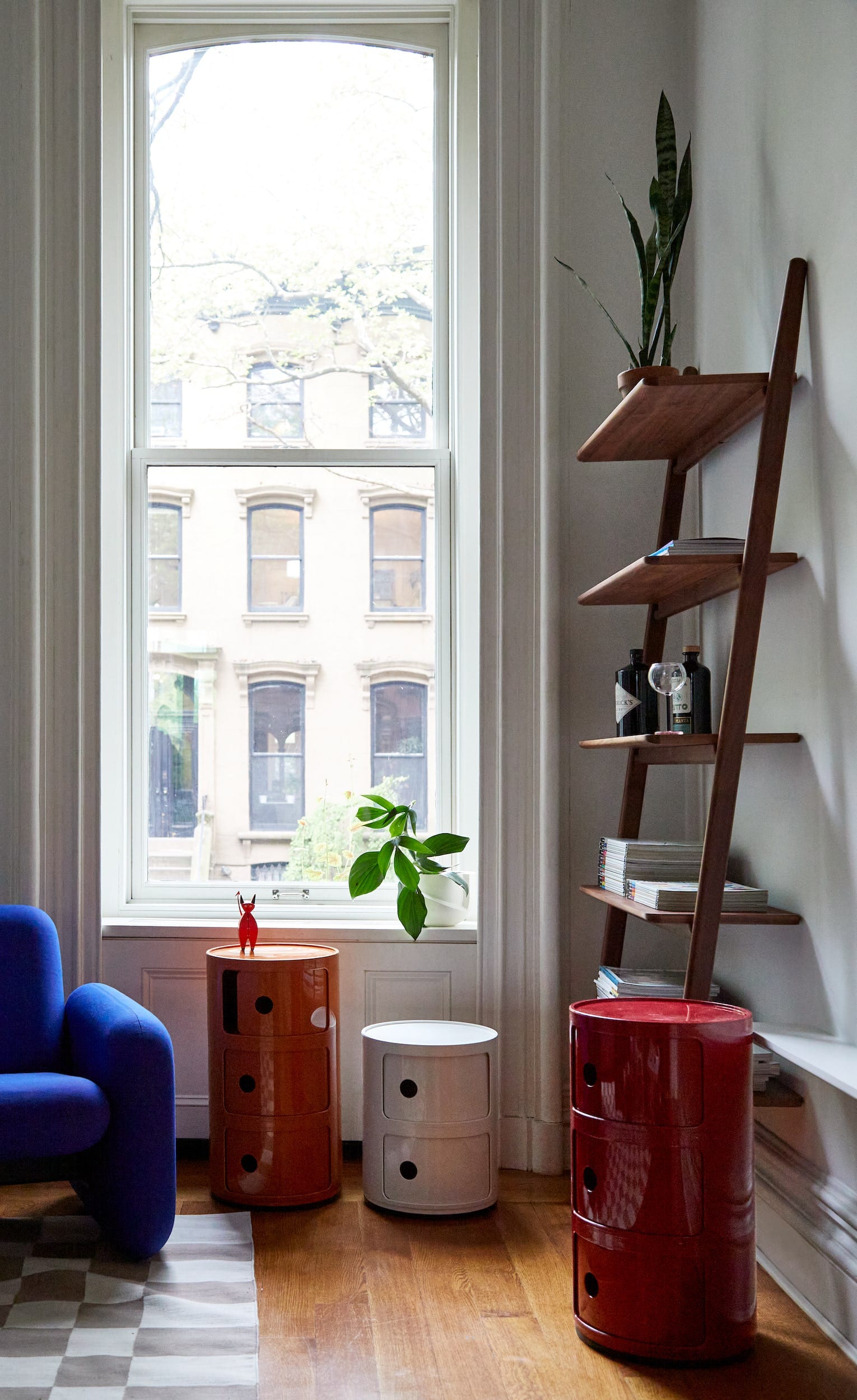 Living room with three Componibili units, one orange, one white, and one red.