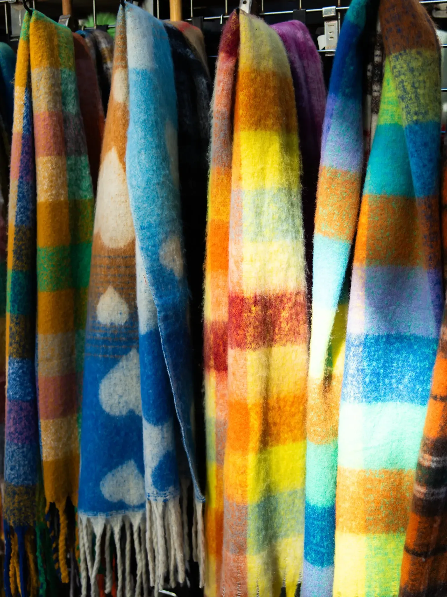 Close up of brightly-coloured plaid scarves.