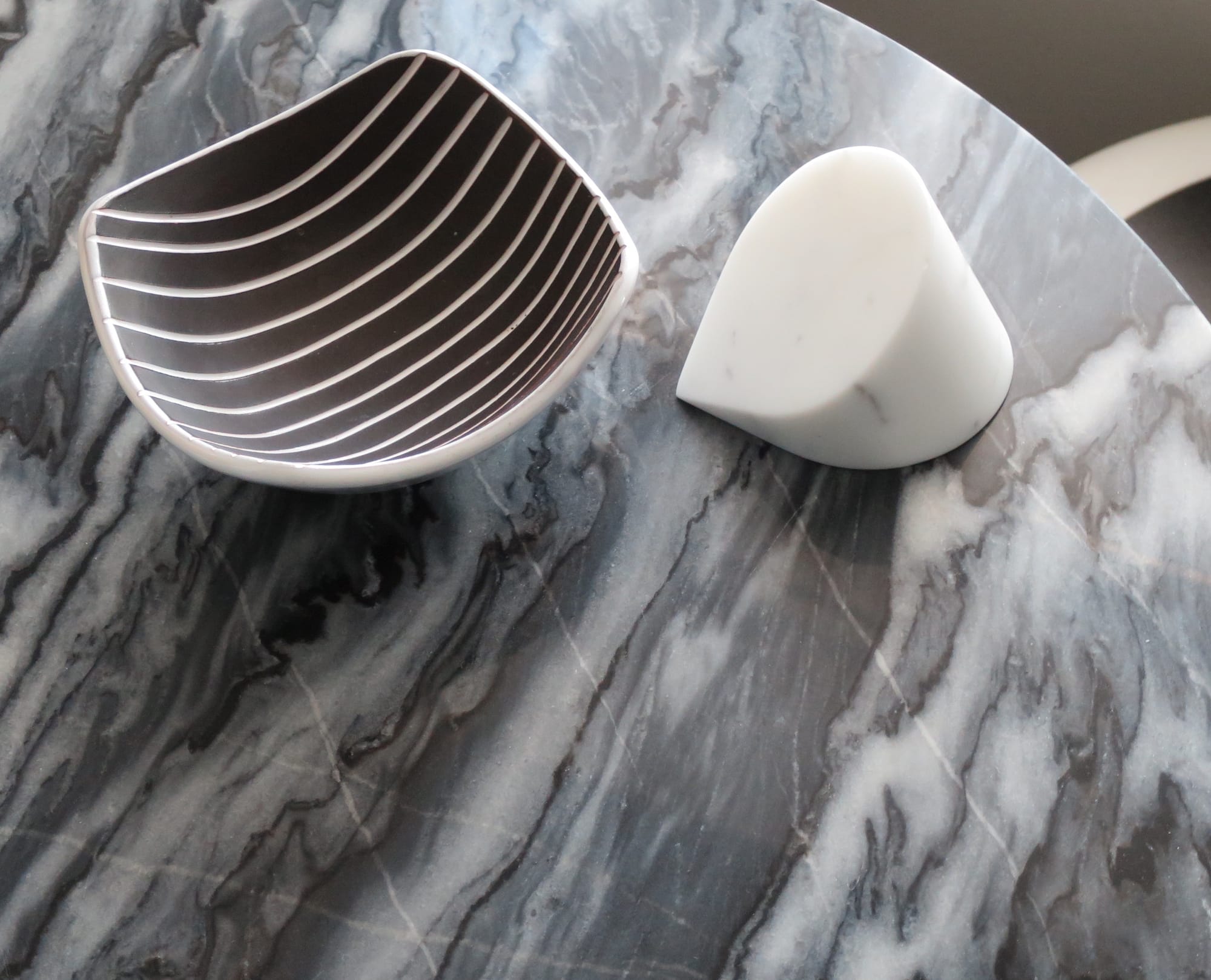 Bowl and paperweight on a grey marble tabletop.