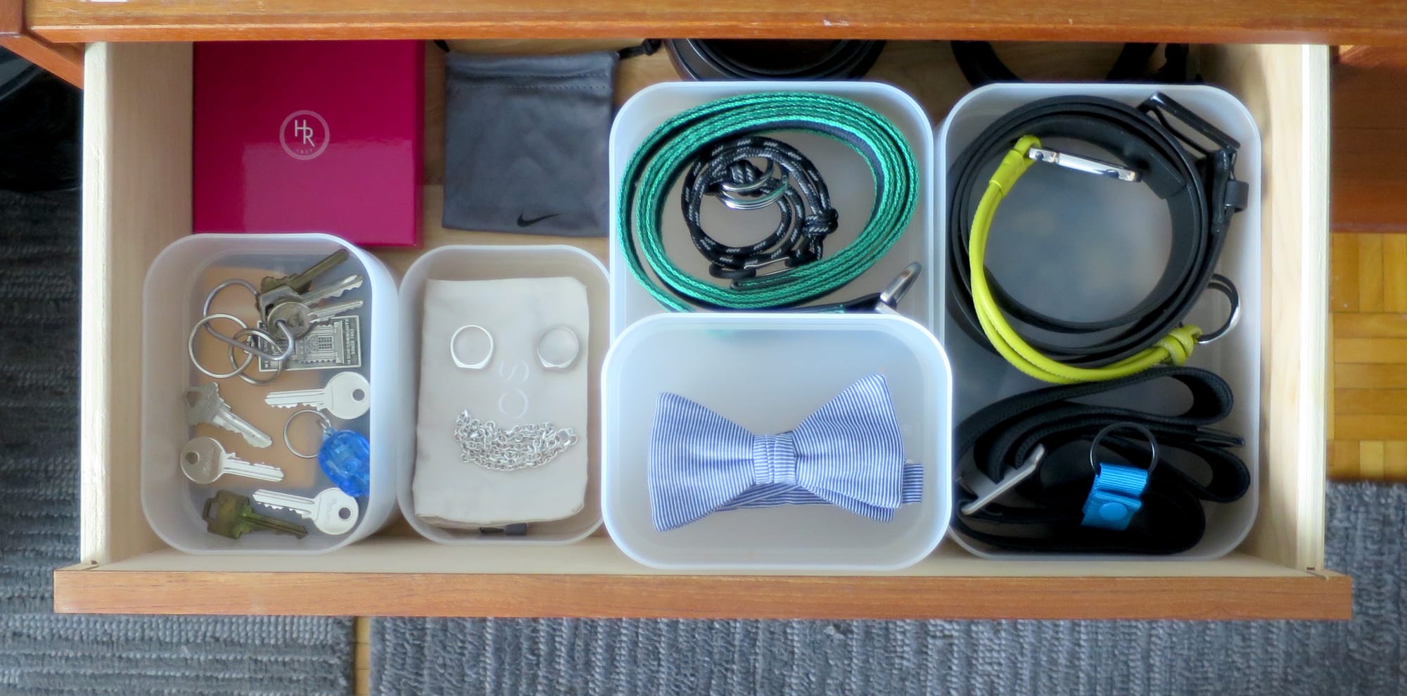 Dresser drawer with compartments for belts, keys, jewelry, and a bowtie.