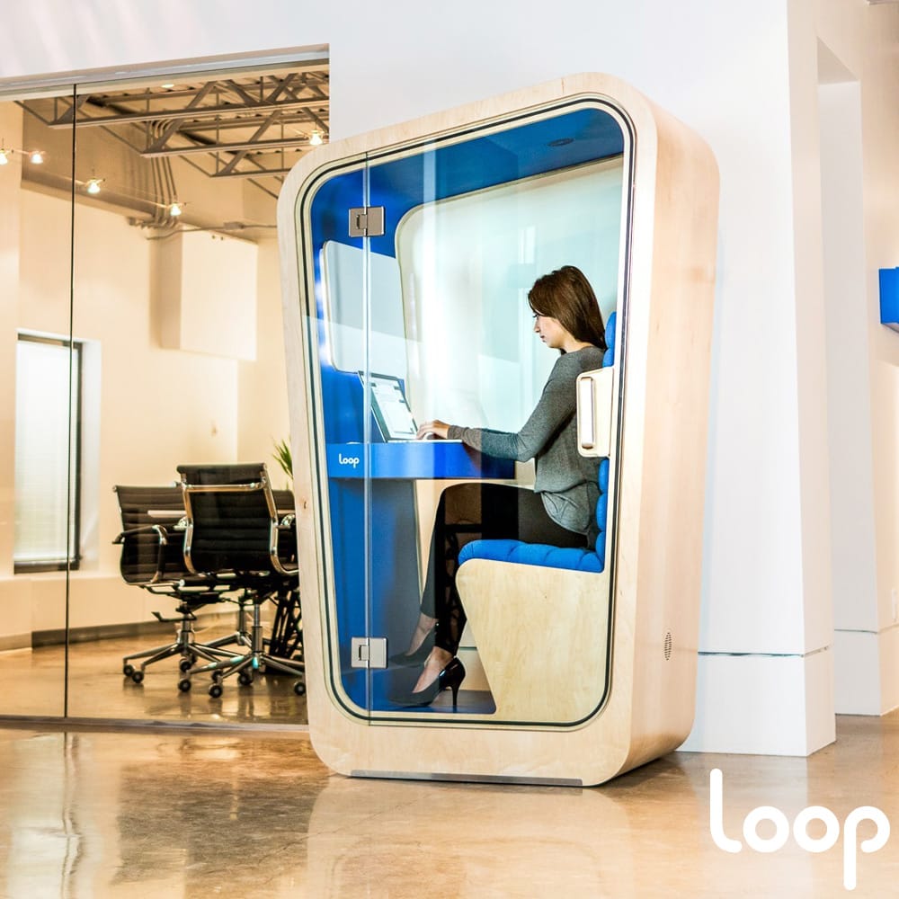 Woman working inside a one-person privacy pod.