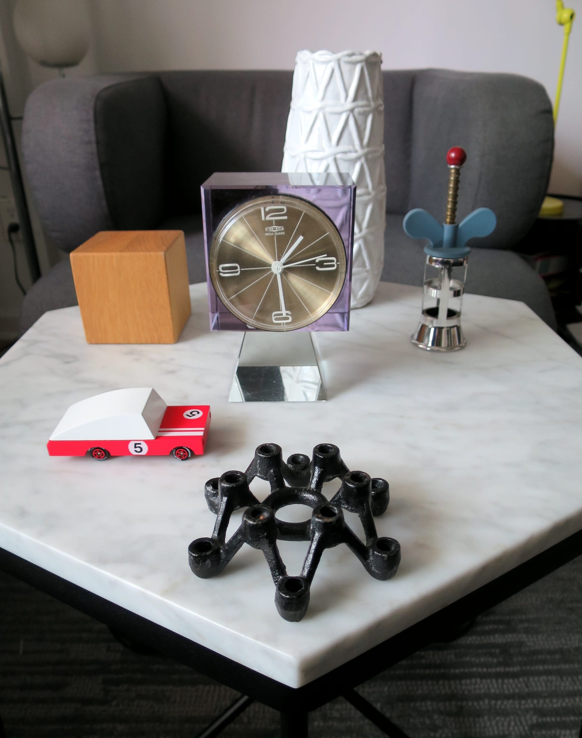 The corkscrew and other small objects arranged on a marble tabletop.