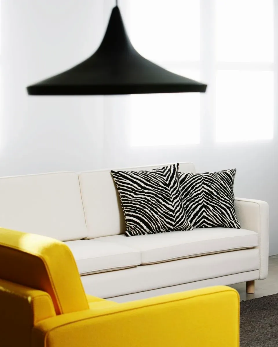 Two pillows with zebra-inspired patterns on a modern sofa.