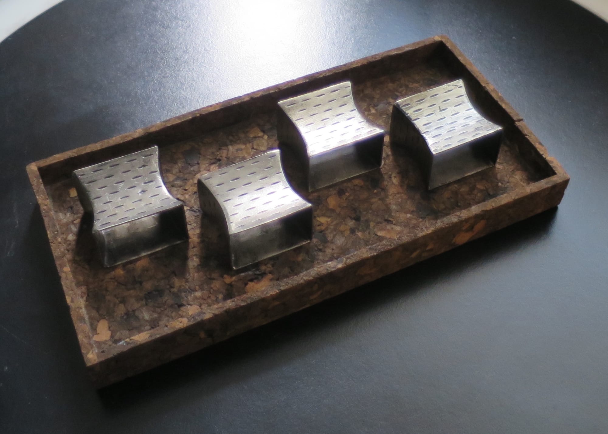 Cork tray with four napkin holders on it.