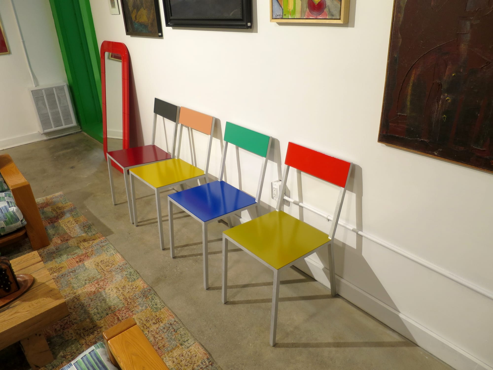 Four chairs with brightly coloured seats and backs.