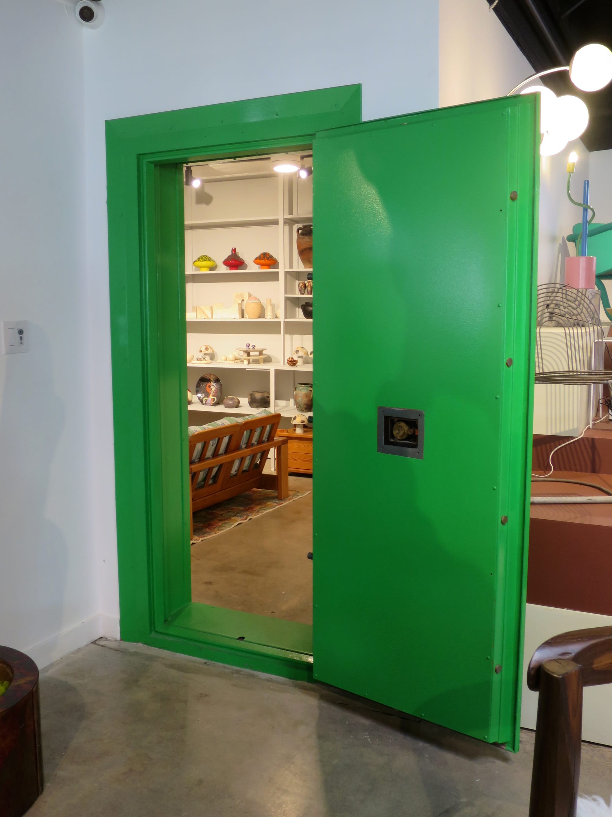 A bright green doorway with objects on shelves visible in the distance.