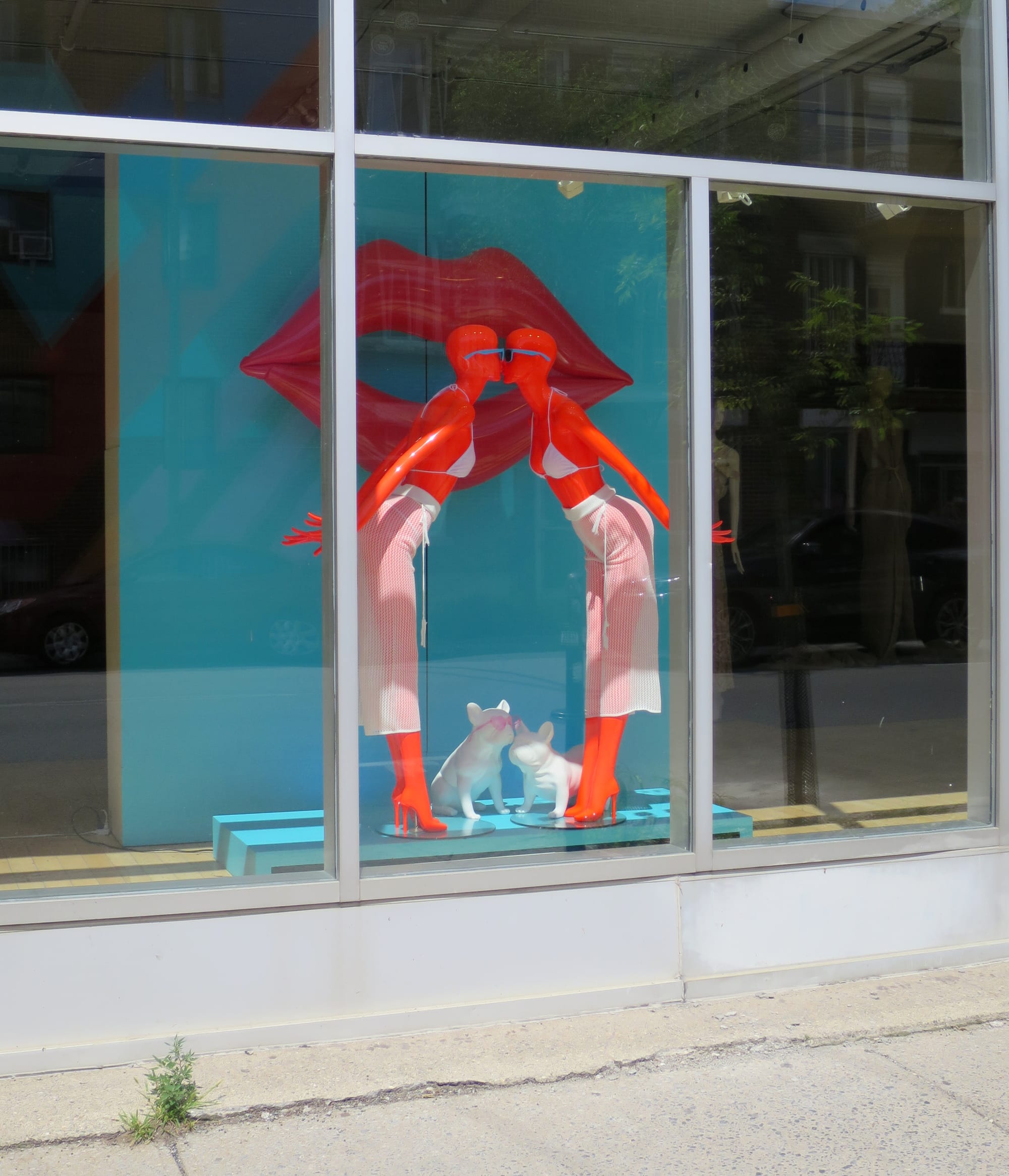 Shop window with bright orange female mannequins.