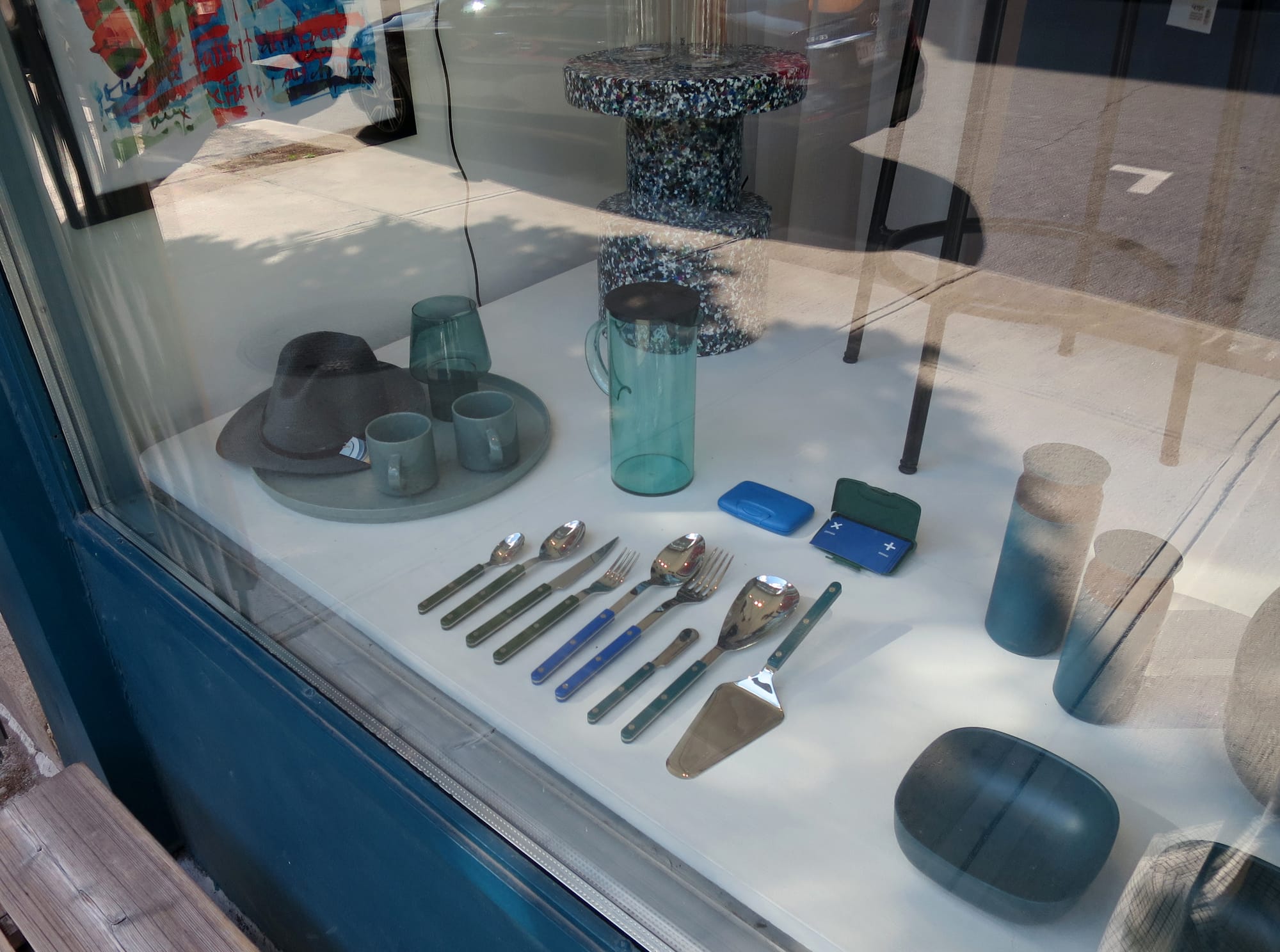 Shop window with household accessories in shades of blue and green.