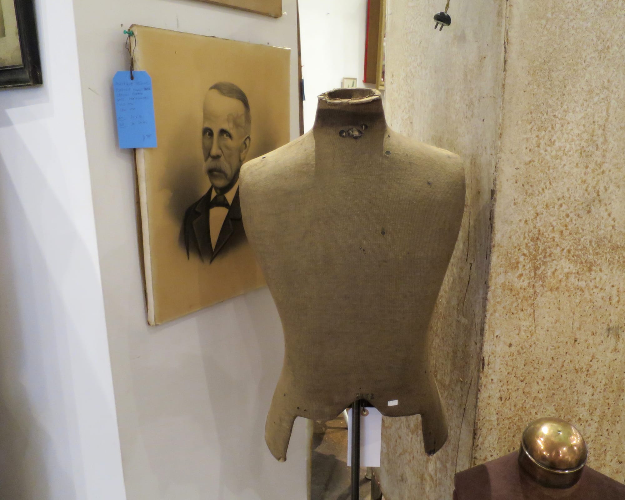 Antique portrait of an old man with dressmakers dummies in the foreground