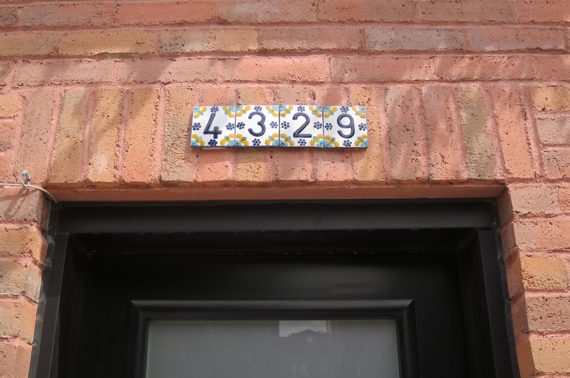 Four decorative tiles showing the street address "4329."