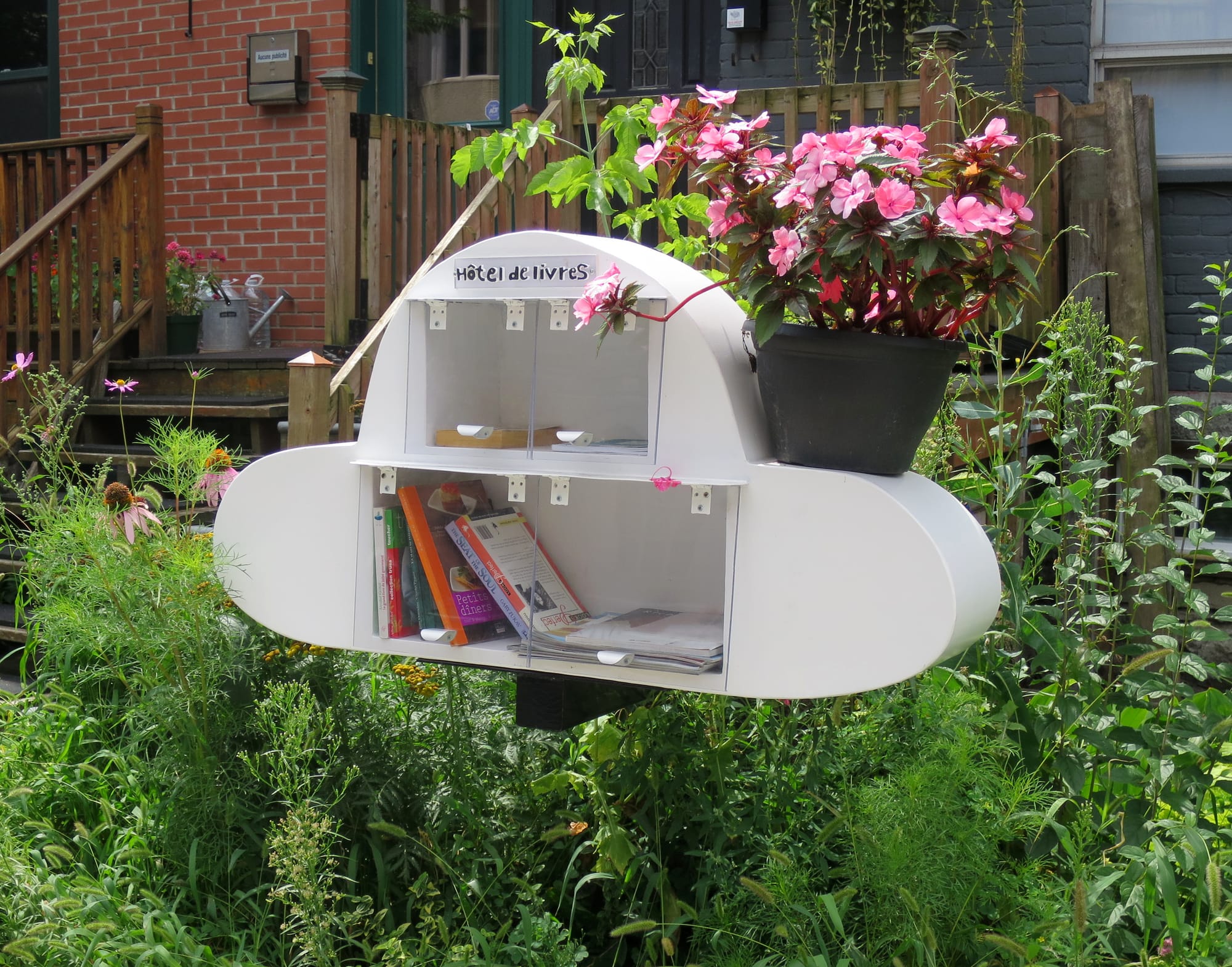 Books inside a white, cloud-shaped structure, with a sign reading "Hôtel de livres."