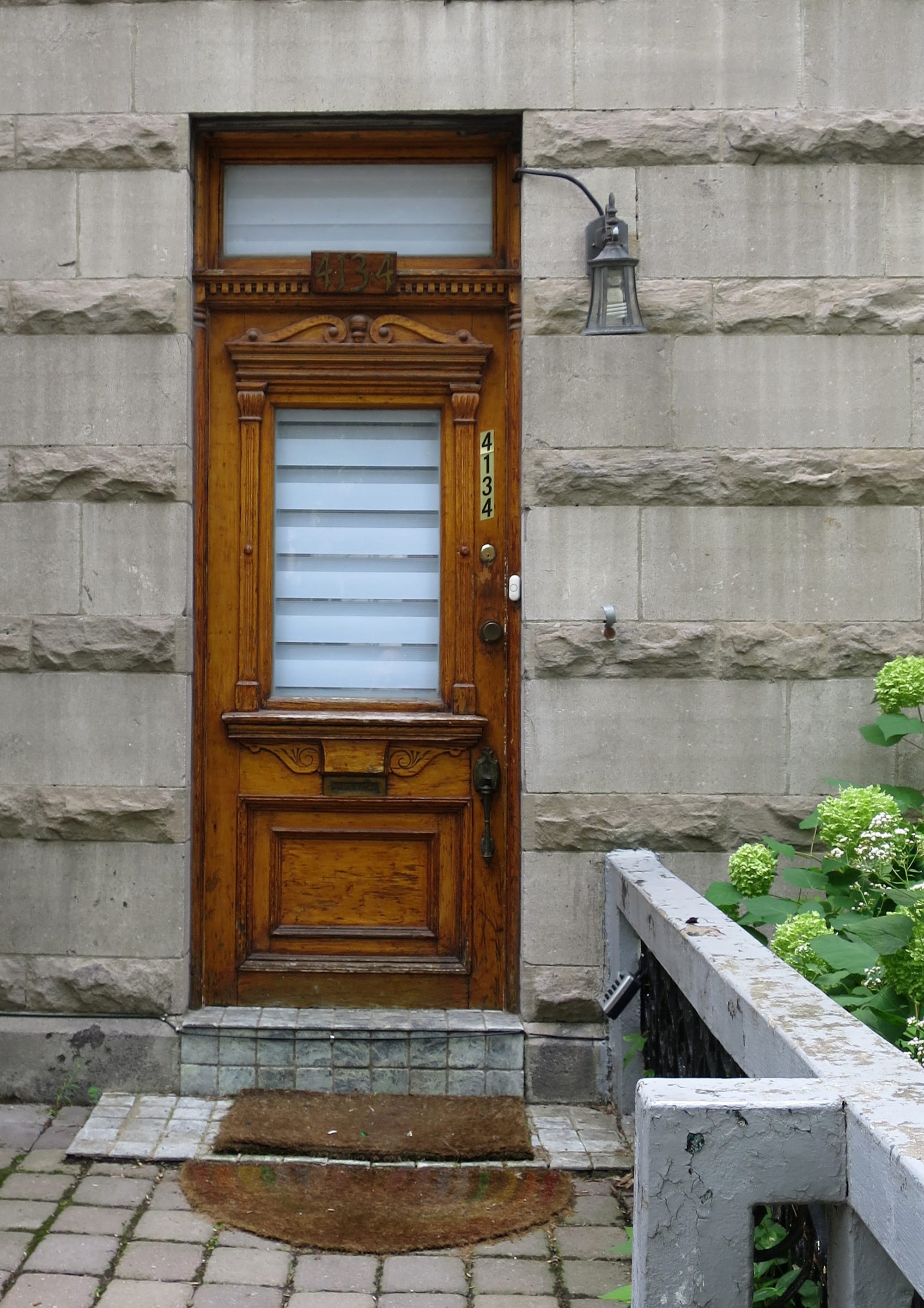 Big old wooden door with two mats in front.