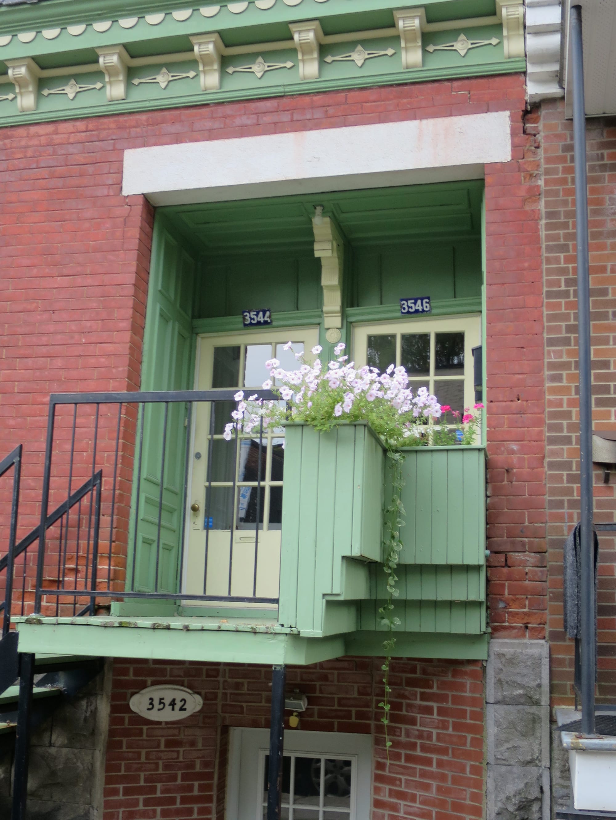 Pink flowers in front of a pair of entrances.