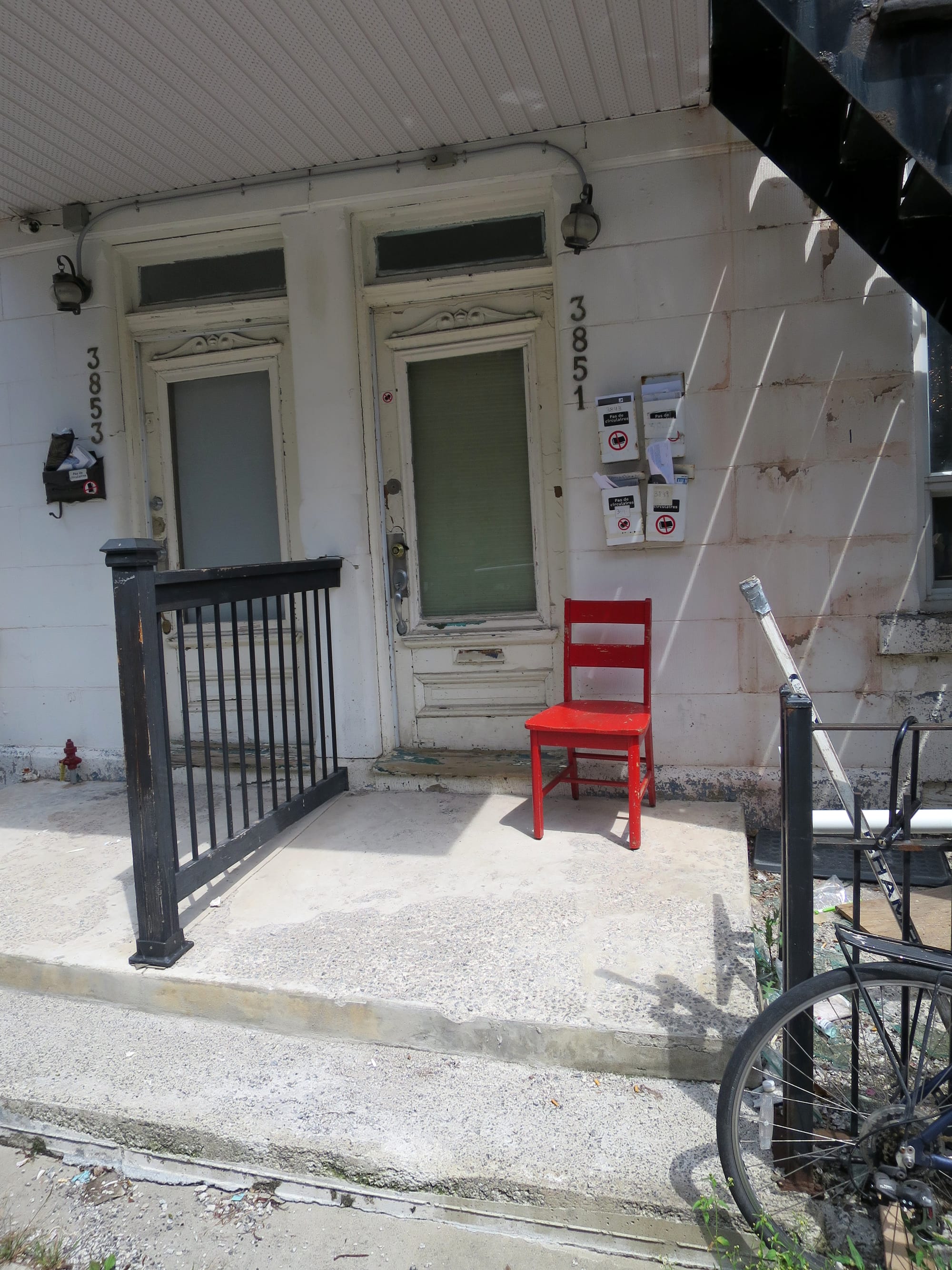 Bright red chair on a porch with no other bright colours.