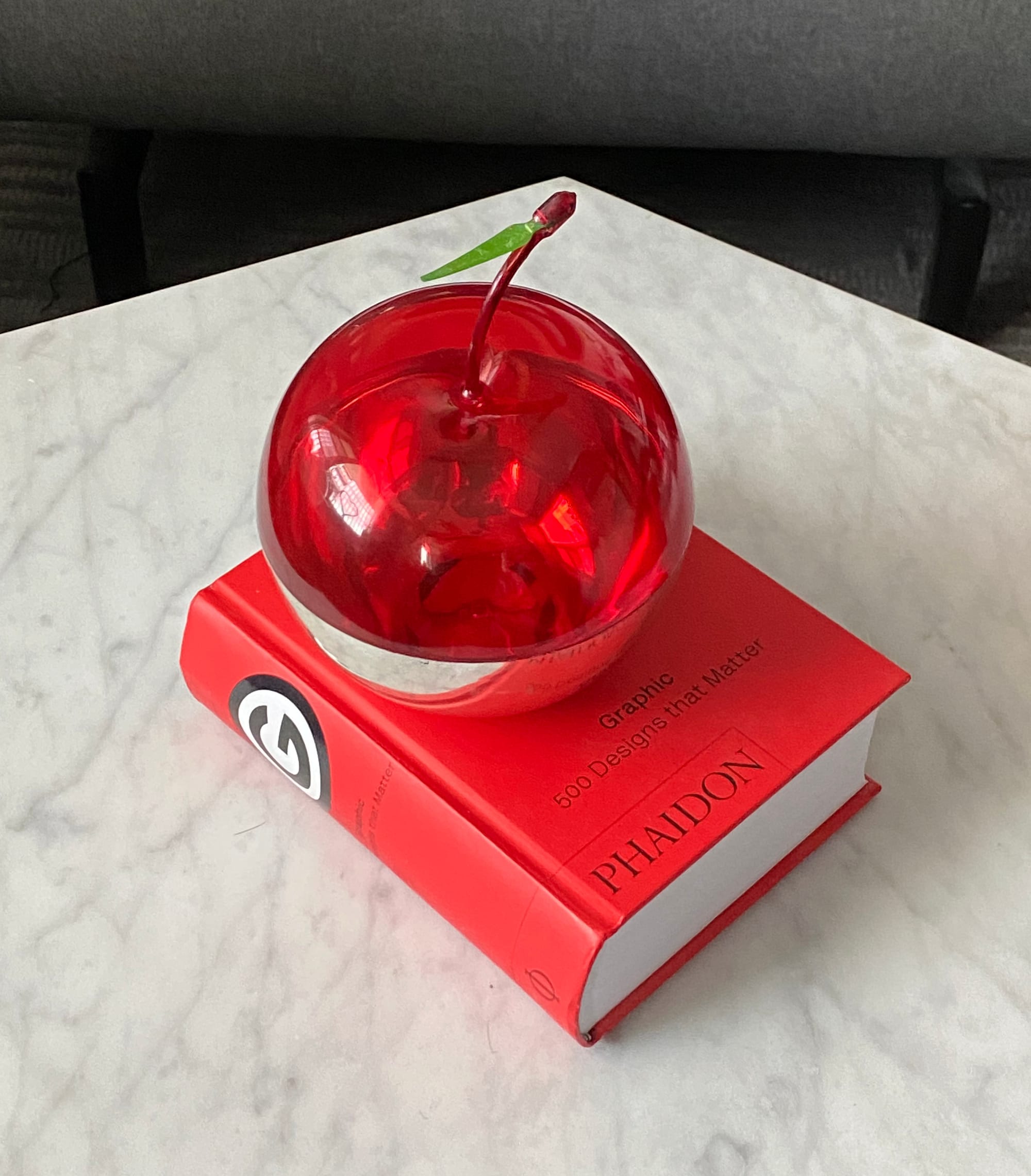 Apple-shaped container resting on a book