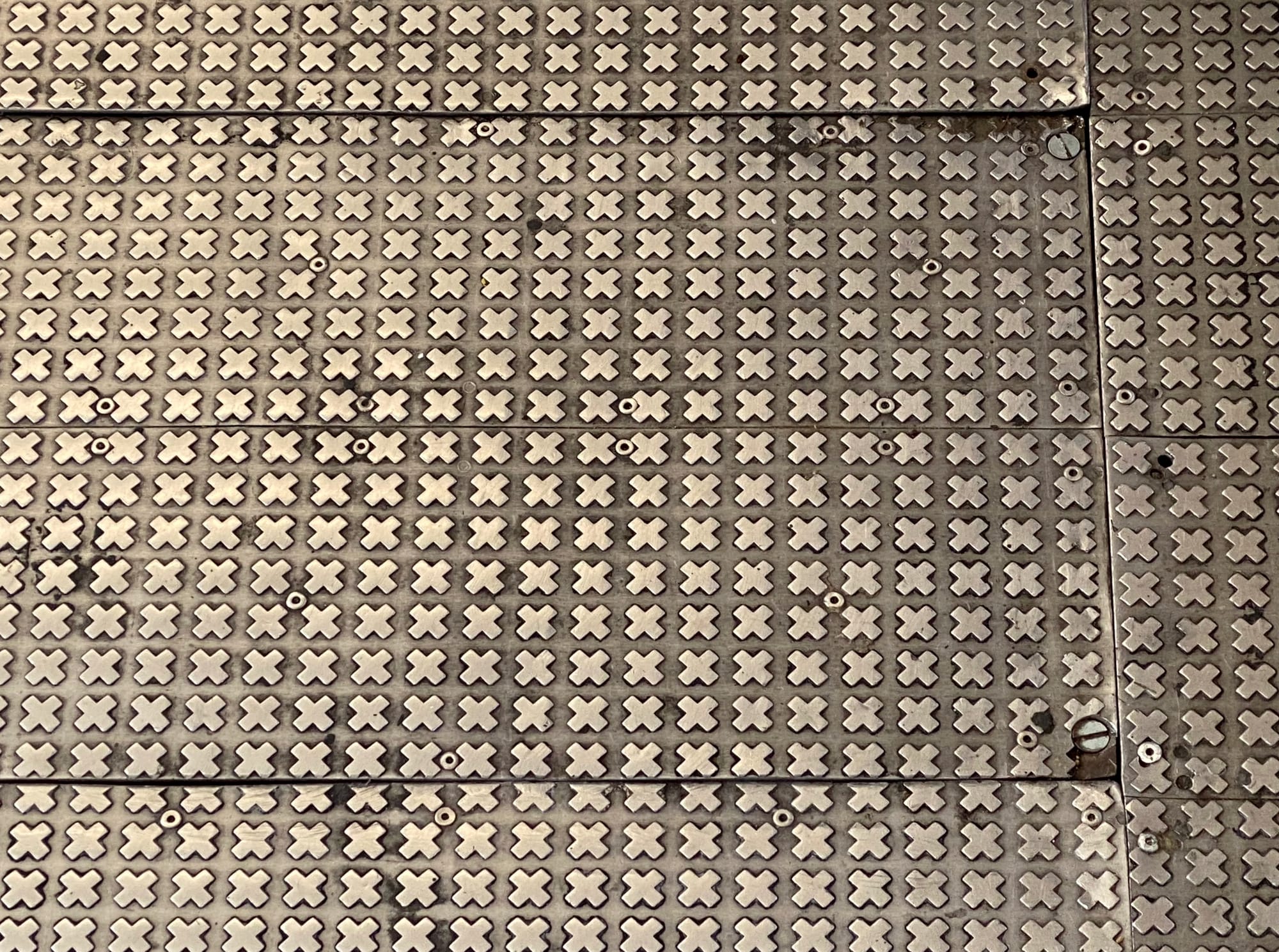 Steel flooring with a pattern of small repeated Xs.