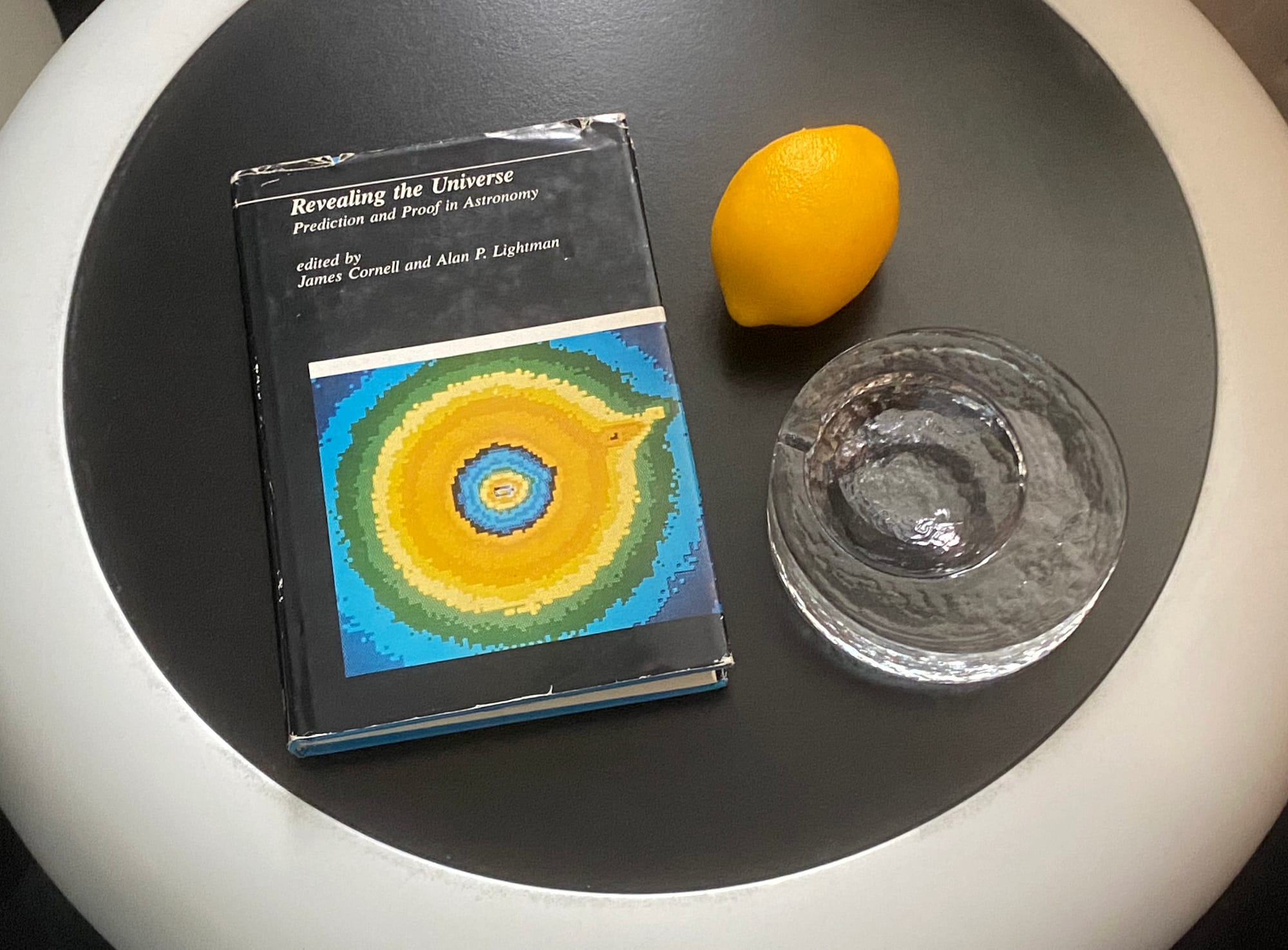 Book, ashtray and fake lemon arranged on a tabletop