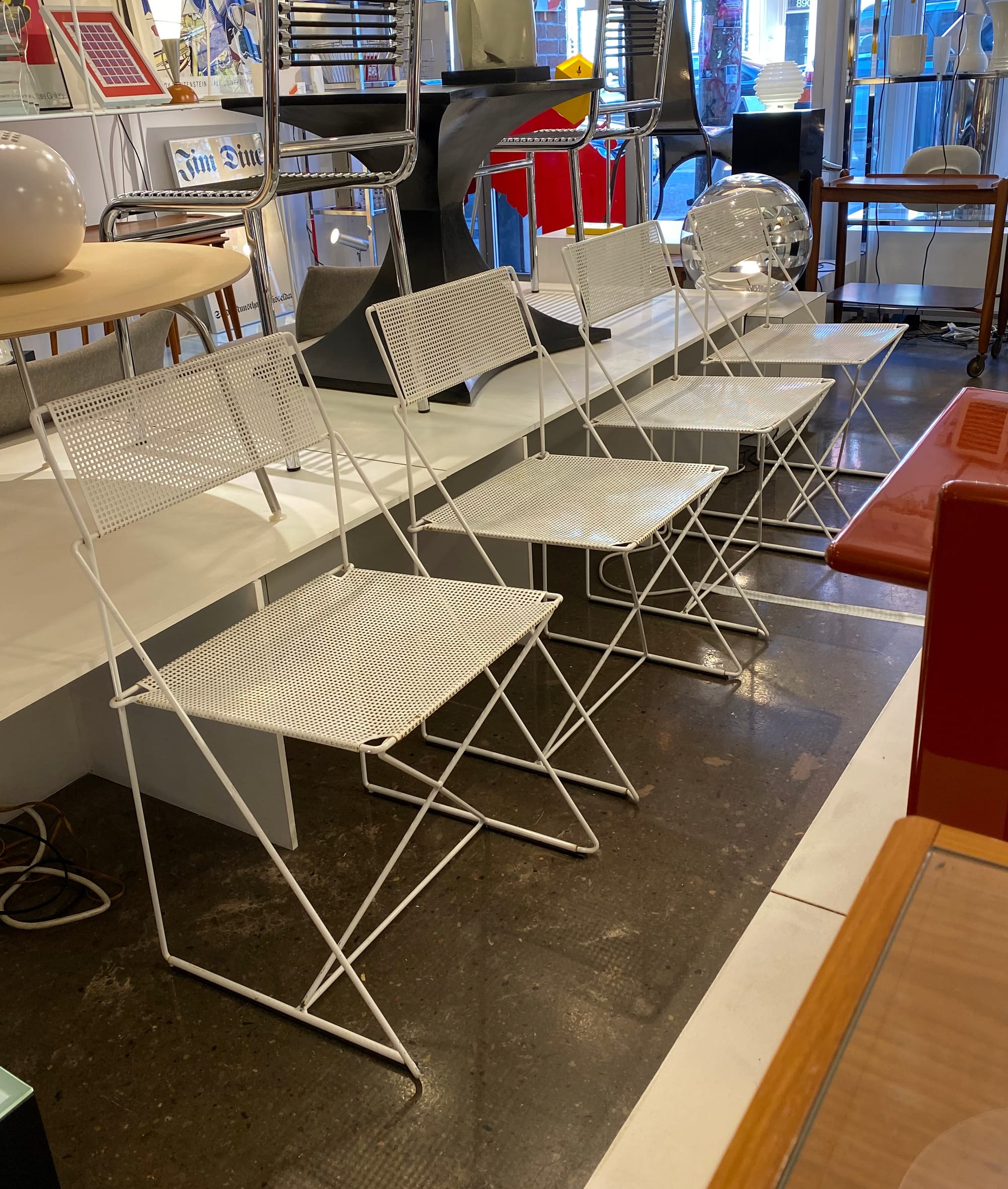 Four X-Line chairs unstacked and arranged in a row.