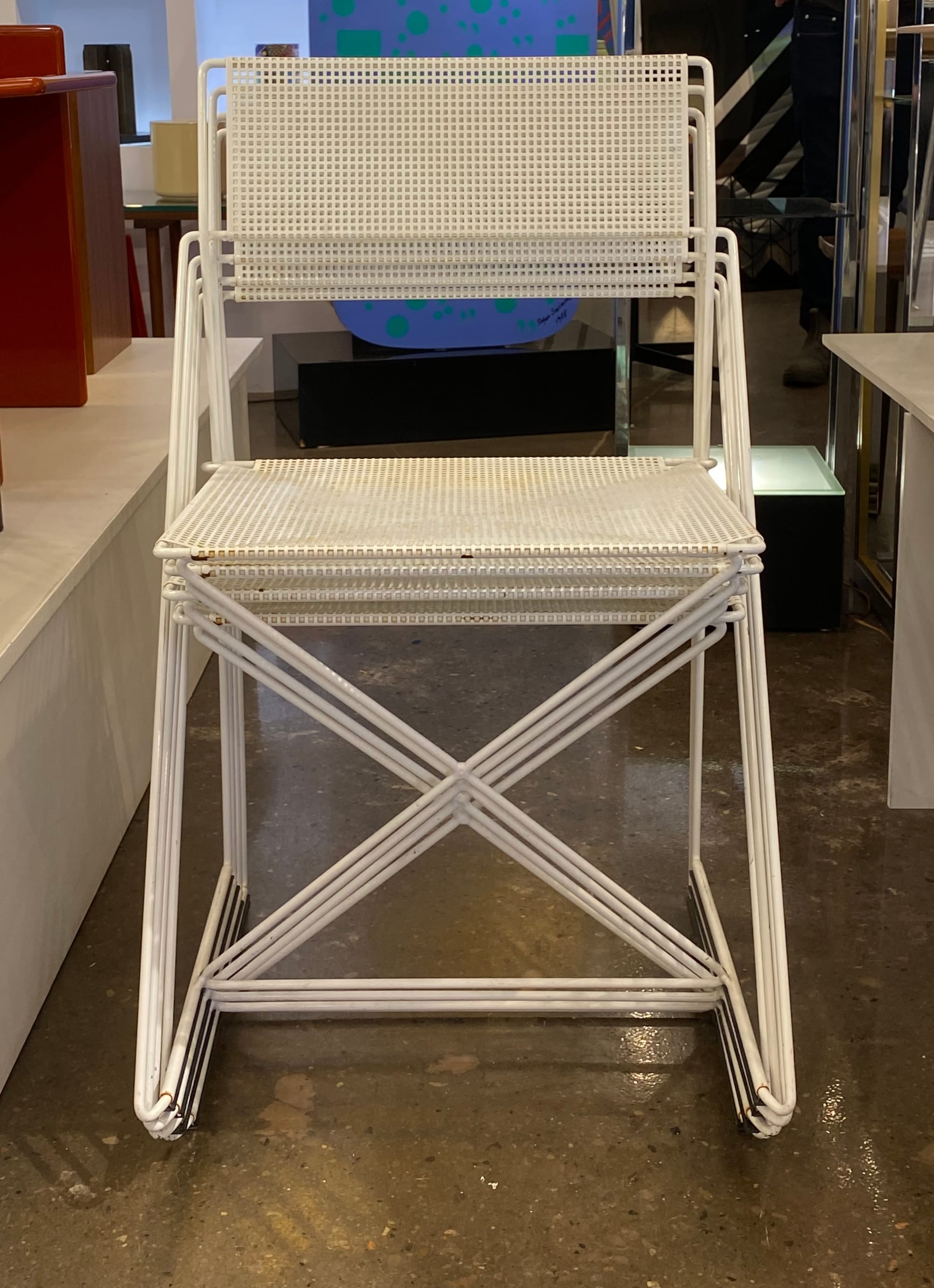 Four stacked X-Line chairs viewed head-on.