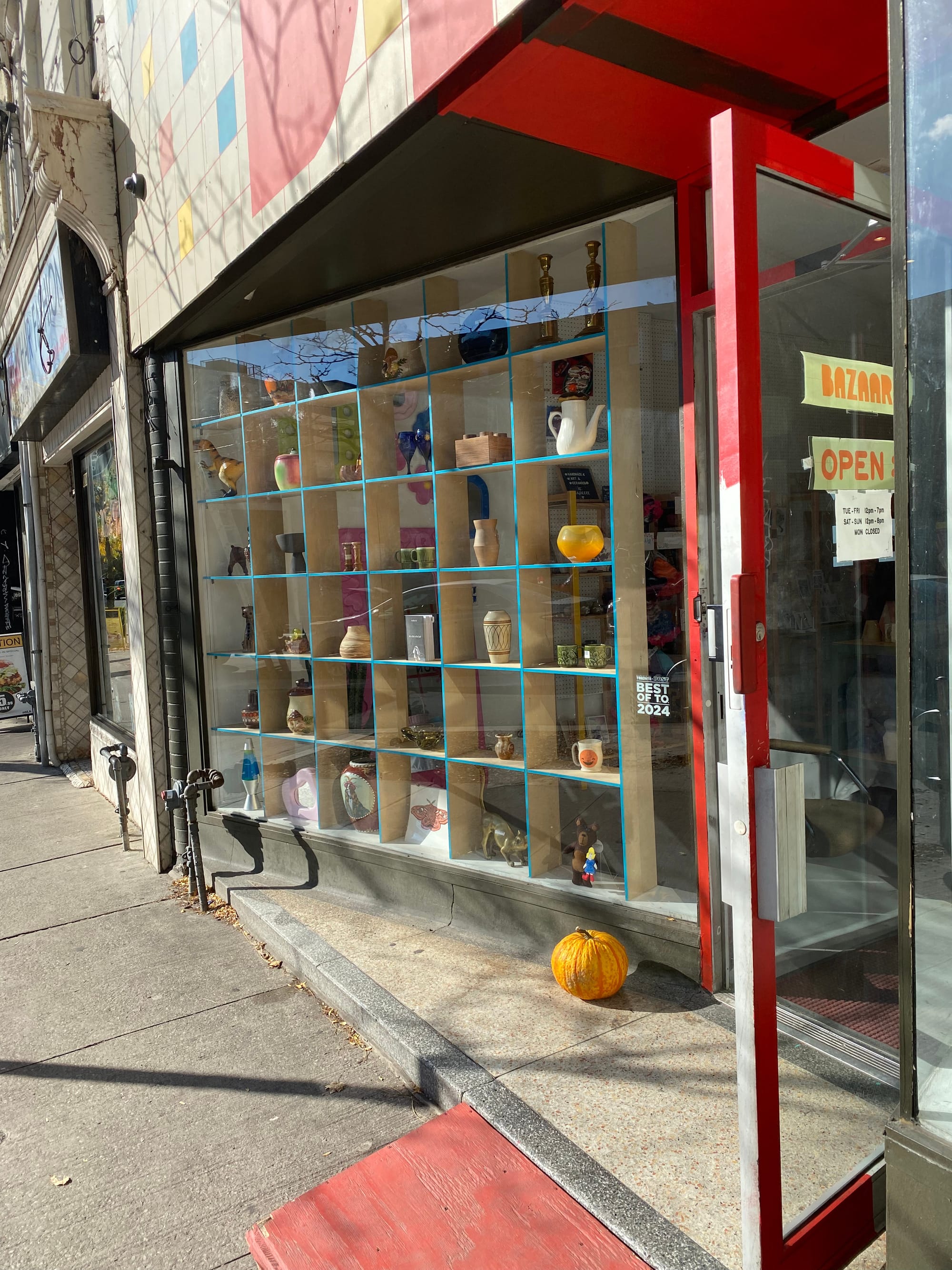 Bazaar Toronto window with a grid holding assorted objects for sale.