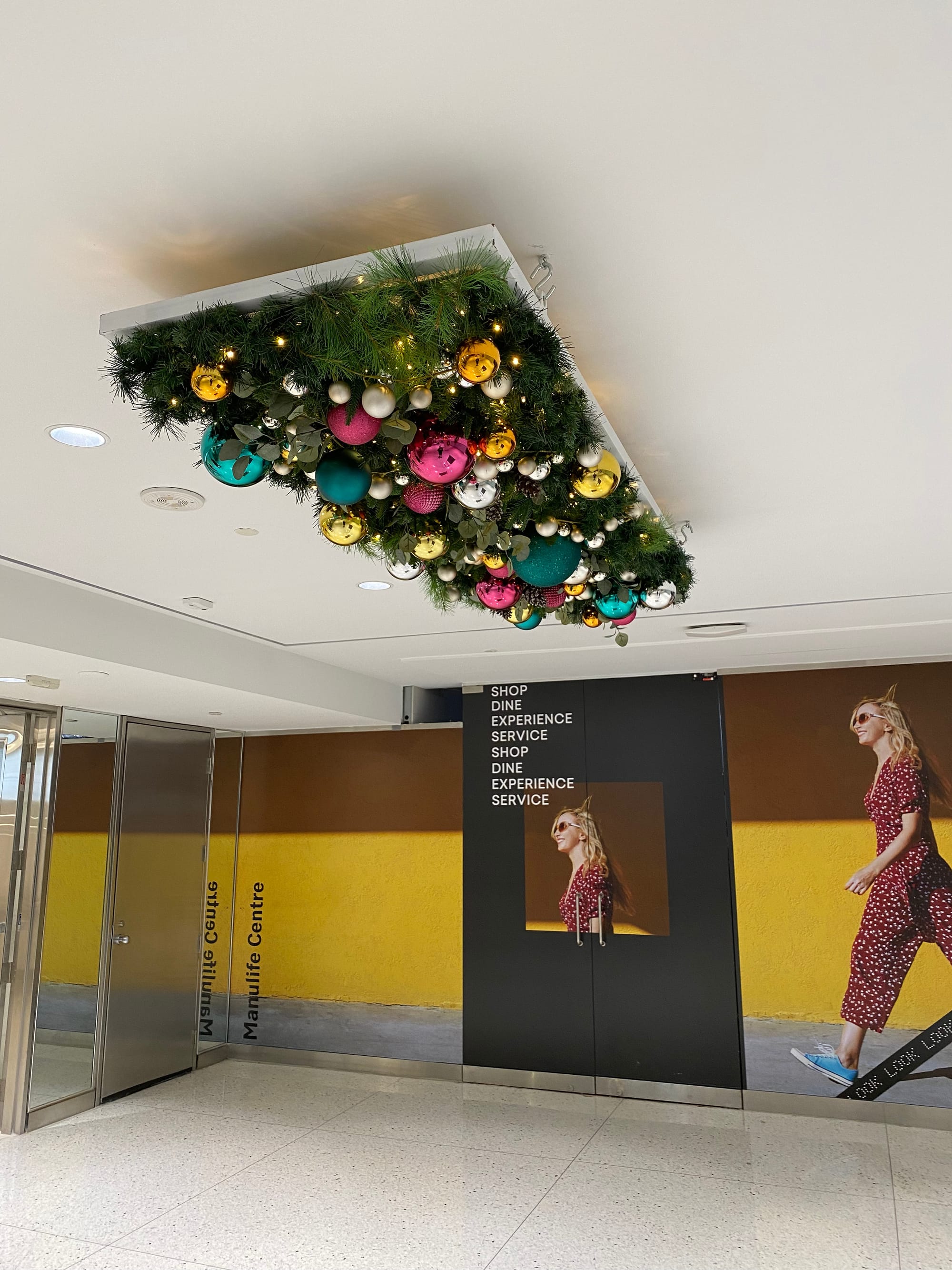 Ceiling panel with artificial pine branches and lots of colourful ornaments.