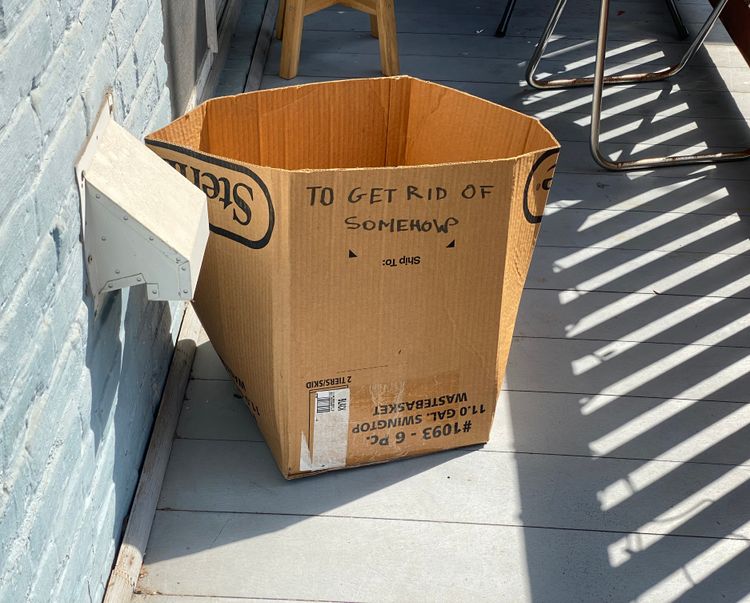 cardboard box with writing on the side that says "to get rid of somehow"