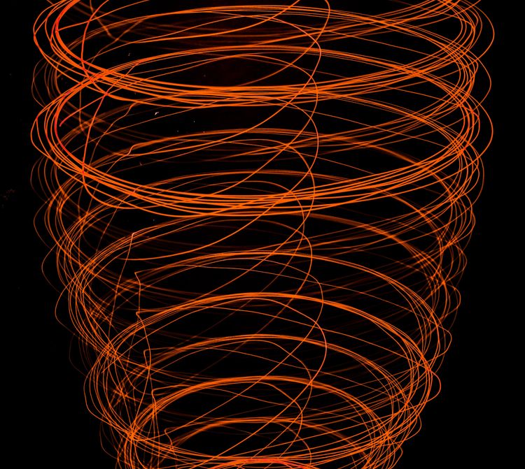 Abstract orange spirals against a black background.