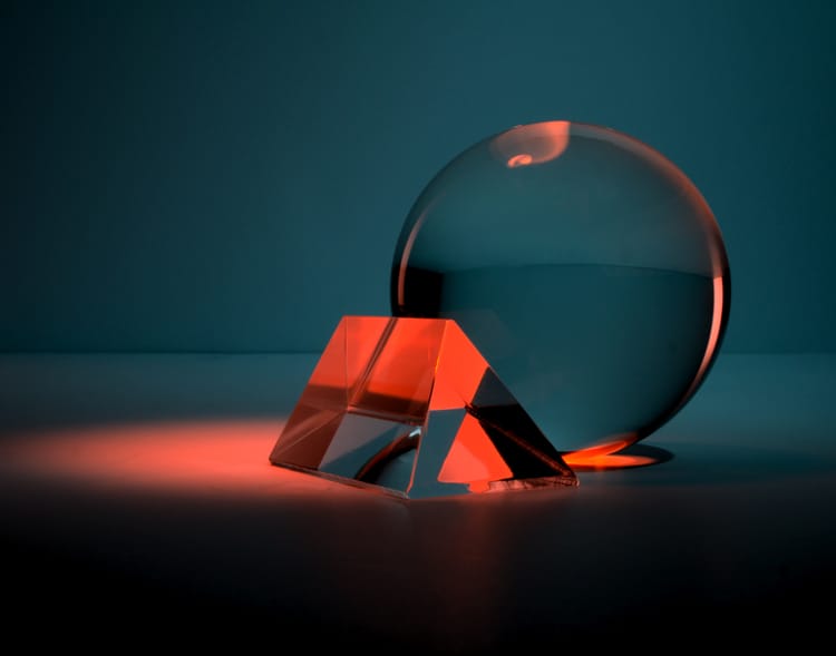 Transparent orb and geometric object lit by a reddish spotlight.