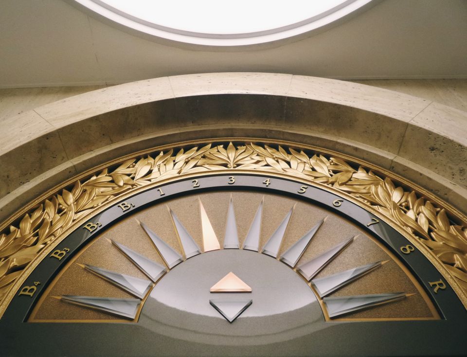 Ornate fixture above an elevator entrance indicating what floor the elevator is on.