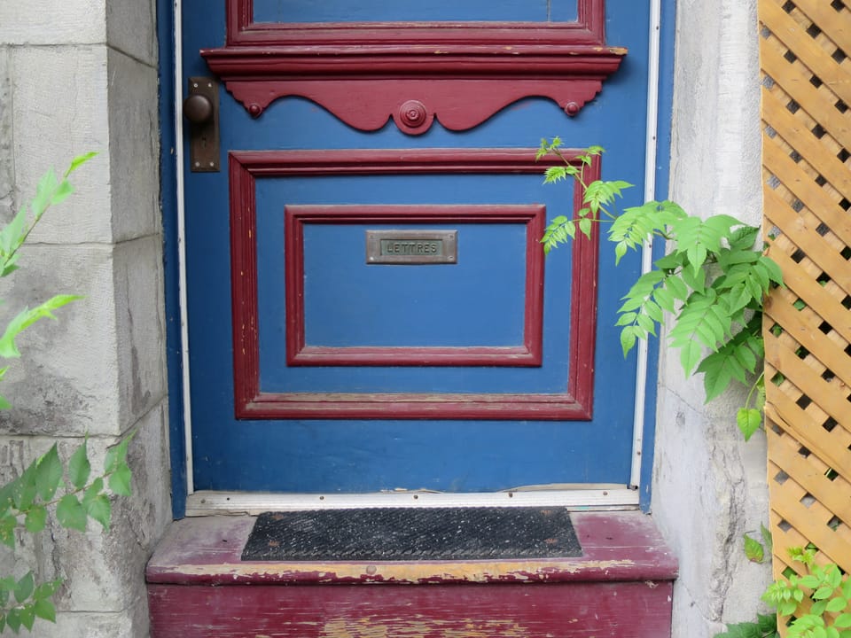 Close up of the lower part of a door, with a slot marked "Lettres."