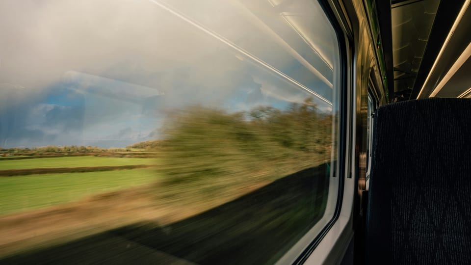 Blurred landscape viewed through a train window.