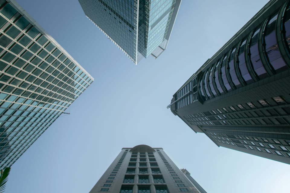 Upward view of four skyscrapers, with the negative space between them in the shape of an X.